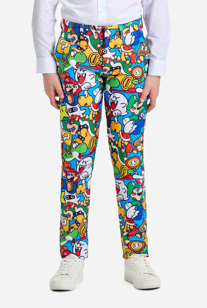 Bild eines Teenagers, der ein Hemd mit Super Mario-Allover-Print trägt, bestehend aus Blazer, Hose und Krawatte. Die Hauptfarbe ist blau, aber es gibt auch gelb, rot und weiß.