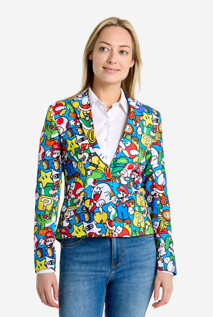 Frau trägt einen Super Mario-Blazer mit Allover-Print und ikonischen Super Mario-Figuren. Die Basis ist hellblau, aber es gibt auch Gelb, Rot und Weiß.