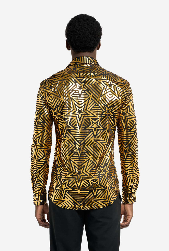 This image features a men’s shirt from OppoSuits with a vibrant gold and black geometric star print pattern. The shirt has a reflective finish that highlights the intricate star and line designs, creating a dynamic and stylish look. Perfect for those who want to stand out, this shirt is both bold and fashionable, ideal for parties, holiday celebrations, or nightlife. The model wears it paired with black pants. View from the back.