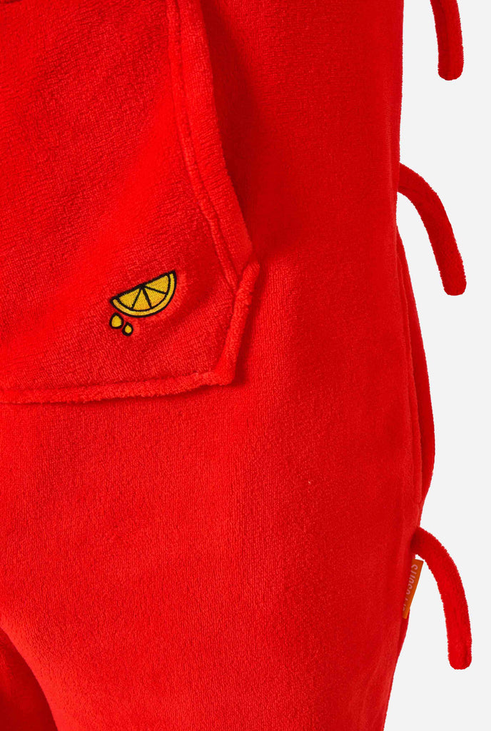 A kid is wearing a bright red lobster-themed kids onesie featuring playful hood details and cozy, soft material. Close up.