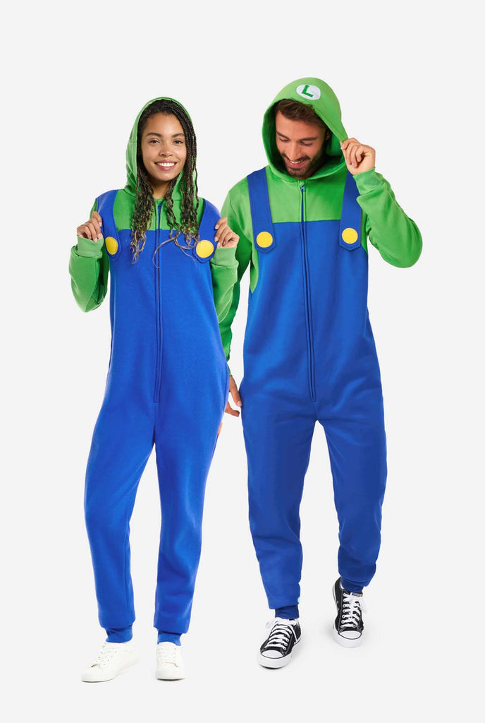 Ein Mann und eine Frau tragen einen Luigi-Einteiler. Das Outfit besteht aus einem hellgrünen Kapuzenpullover mit einem „L“-Symbol auf der Kapuze und einem blauen Overall mit großen gelben Knöpfen an den Trägern. Das Gesamtdesign imitiert das Aussehen der beliebten Videospielfigur Luigi mit kontrastierenden Grün- und Blautönen. Der Hintergrund ist schlicht und legt den Fokus auf das Kostüm. Full body image