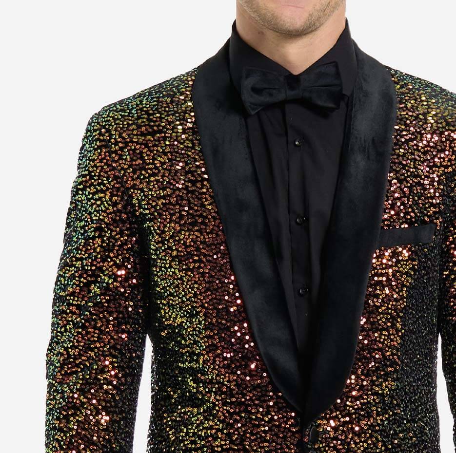 Close up of a man wearing a sequin blazer, a black shirt and a black tie. Sequin blazer has a black satin lapel.